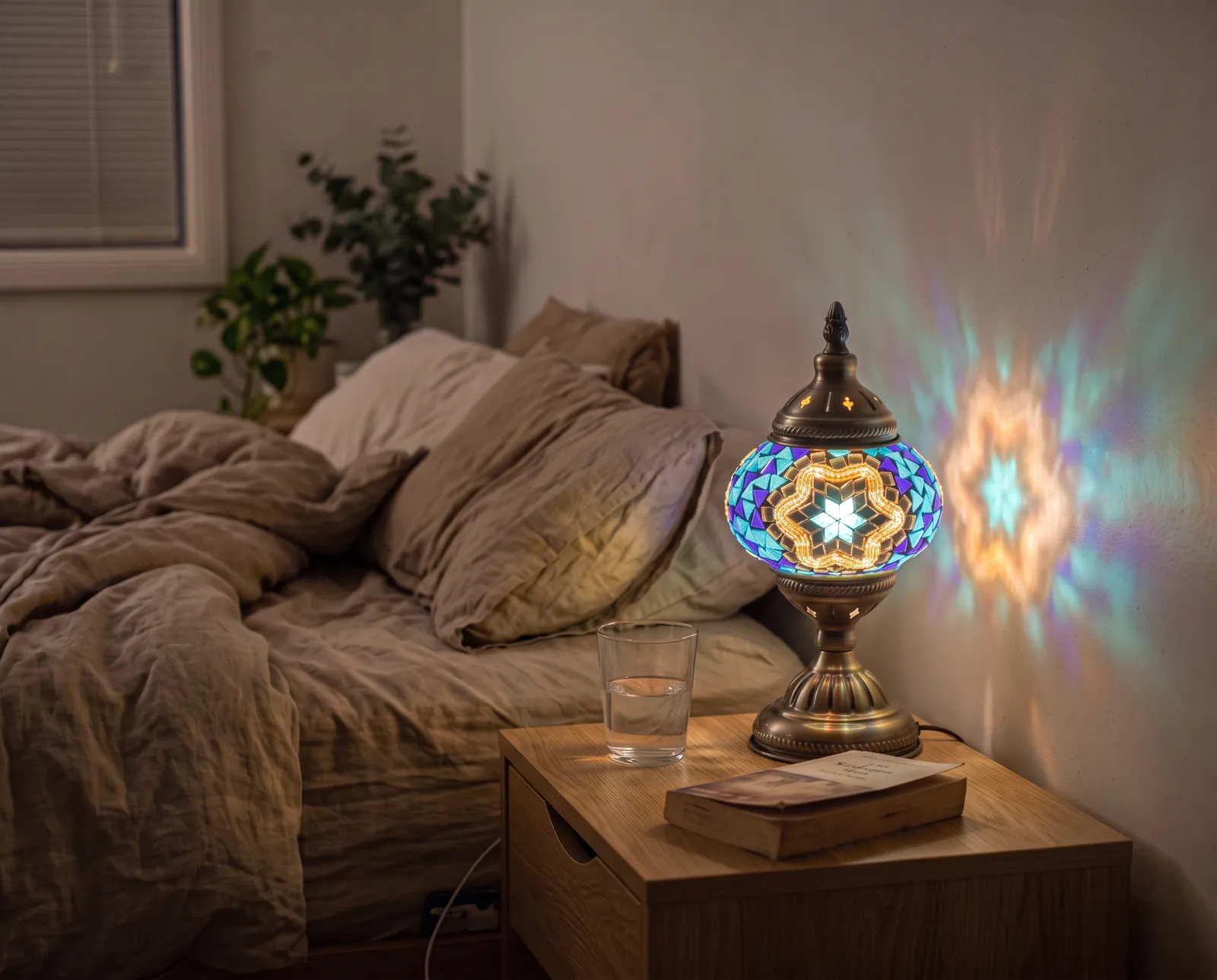 The Ocean lamp lit on a bedside table